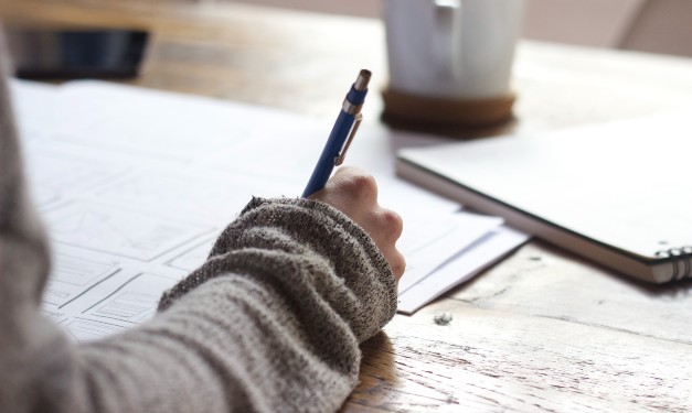 Person writing at desk