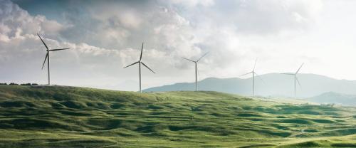 Wind turbines on hill in mist