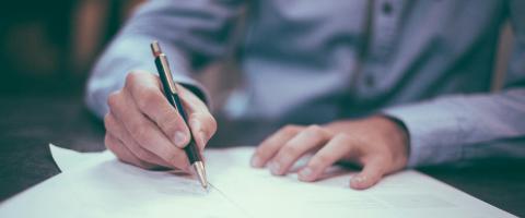 Person signing document - photo: Scott Graham